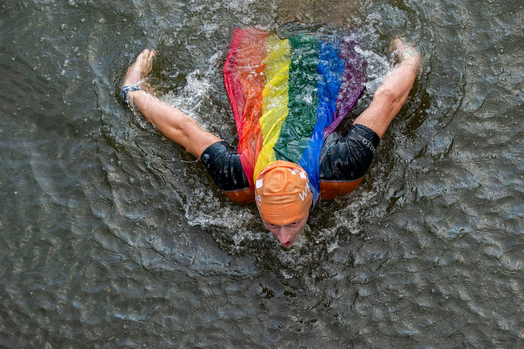 Teun Zijp zwemt vlinderslag met regenboogcape